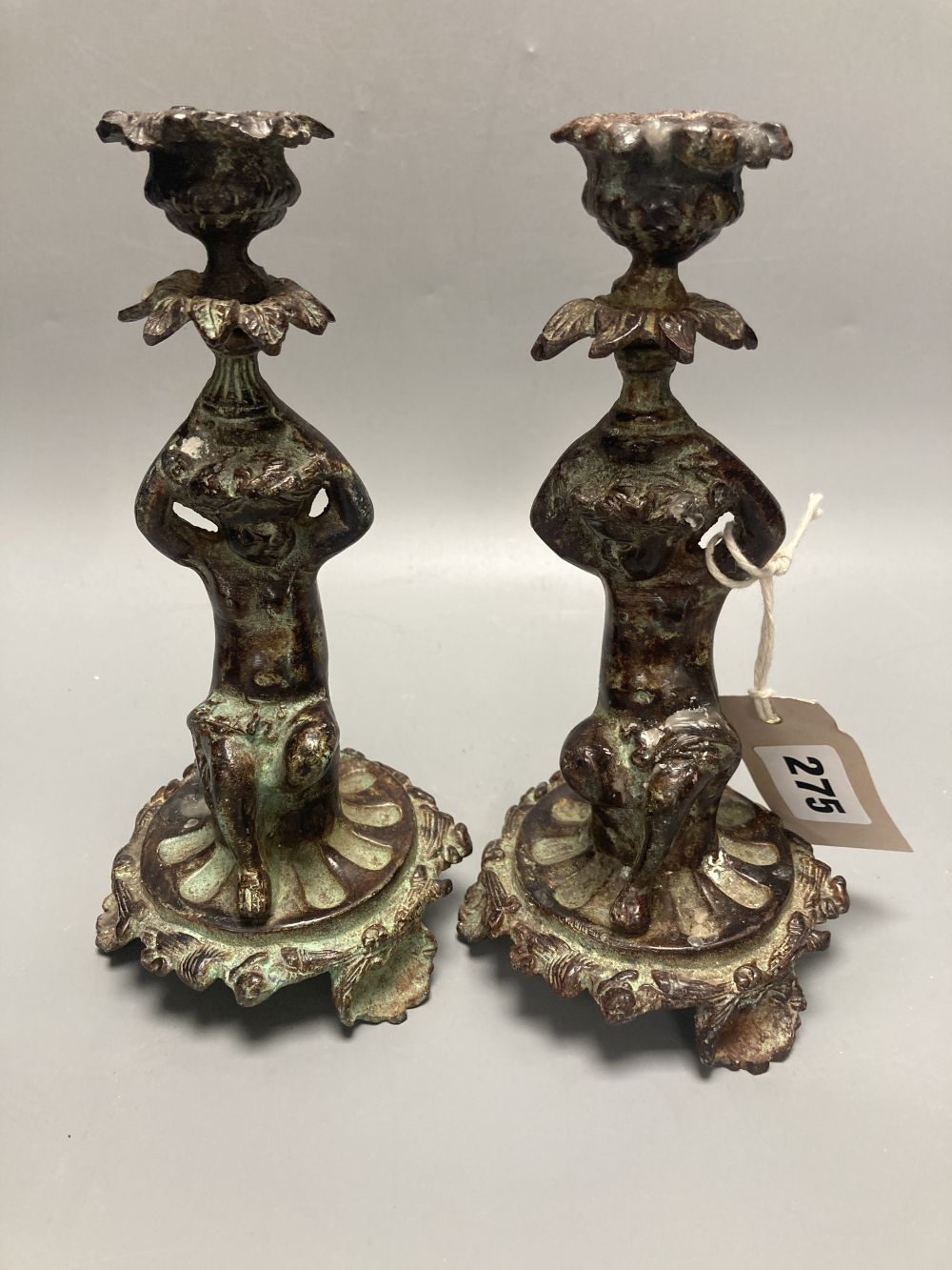 Two patinated metal putti candlesticks, height 20cm